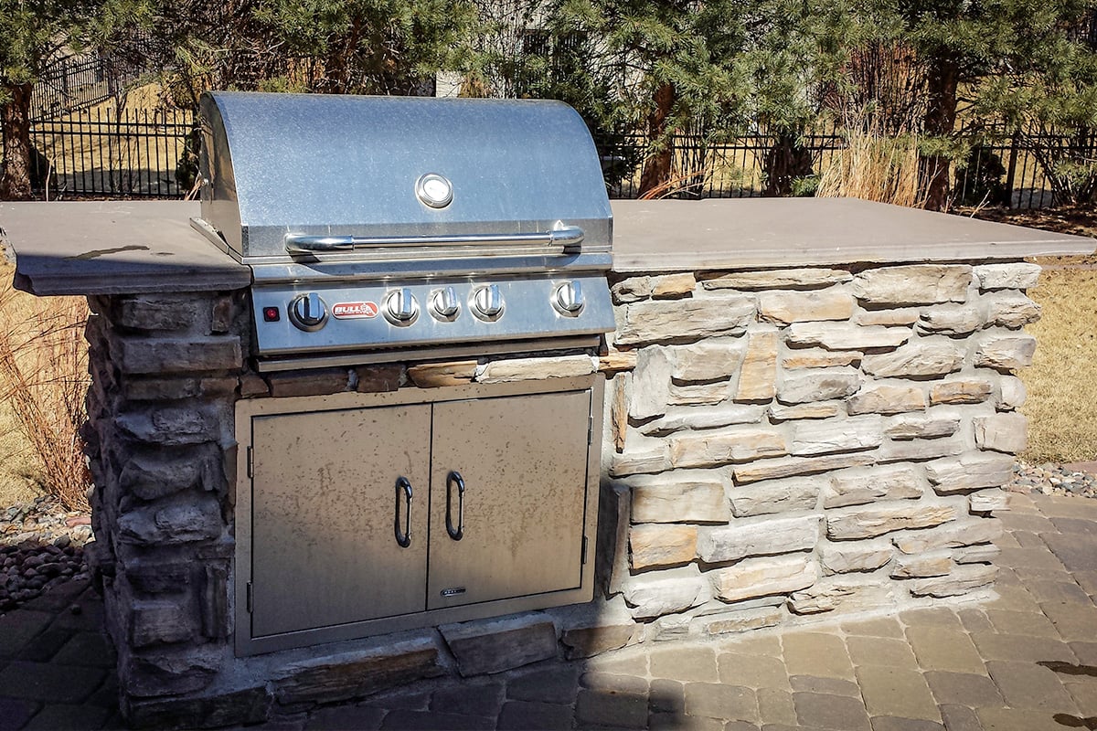 outdoor grill built into rock designed by jay moore landscaping
